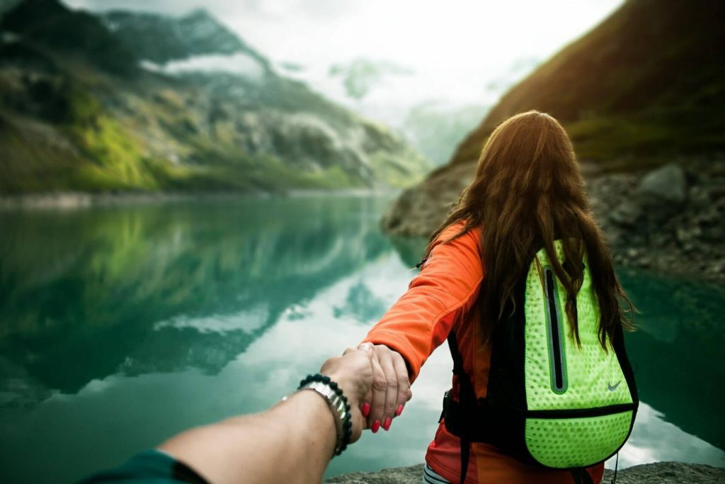 Viajera con mochila junto a un lago