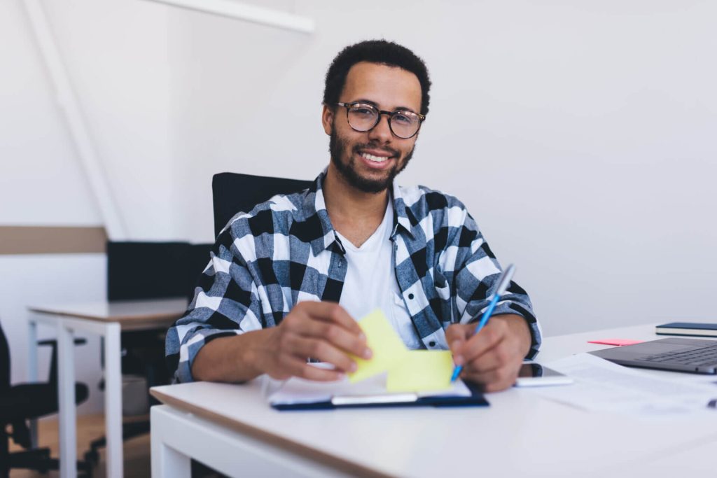 Estudiante extranjero posando en el escritorio