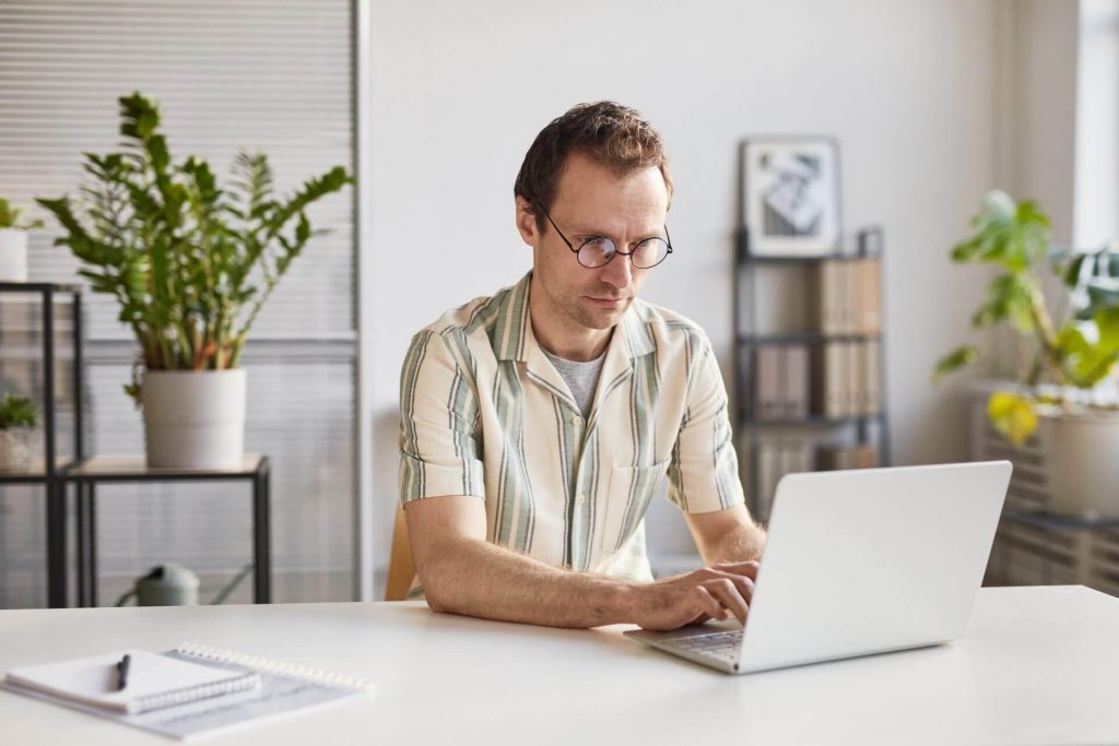 Hombre consultando el estatus de su caso de USCIS con el número de recibo desde su laptop