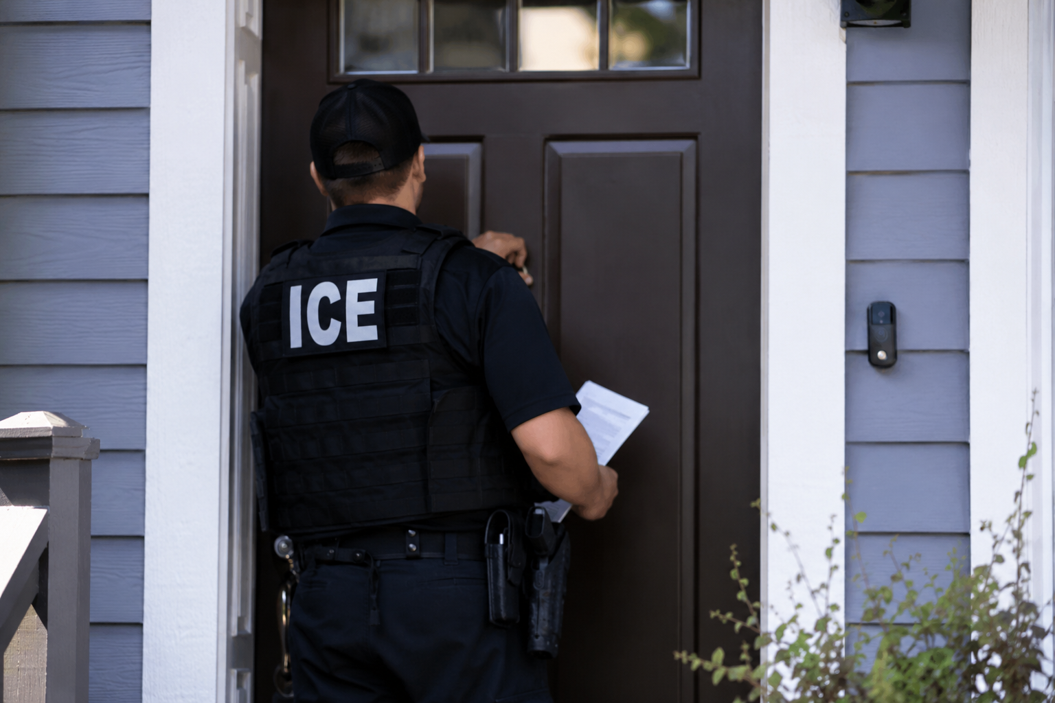 Oficial ICE tocando puerta de casa